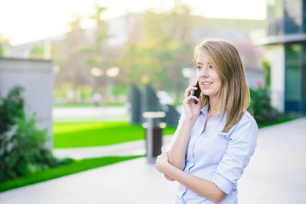 Retrato al aire libre de una hermosa morena feliz o mujer de negocios de treinta años hablando por su teléfono celular — Foto de Stock