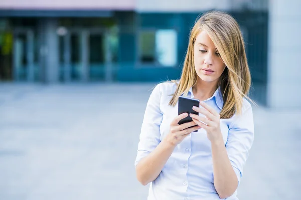 Retrato de jovem alegre falando no smartphone e rindo ao ar livre. Mulher branca bonita feliz usando telefone celular, fazendo chamada na rua no verão. Espaço de cópia — Fotografia de Stock