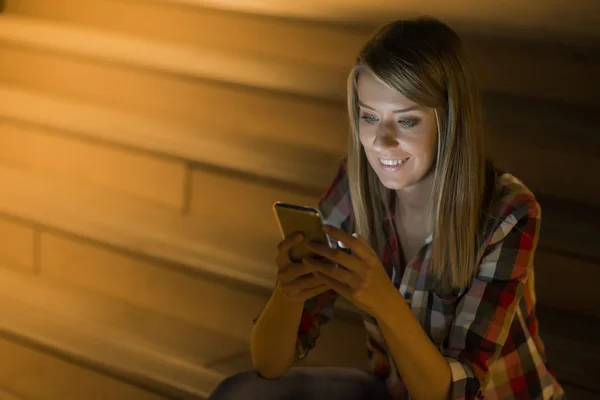 Boas notícias. Jovem mulher feliz sorrindo mensagens de texto em seu telefone — Fotografia de Stock