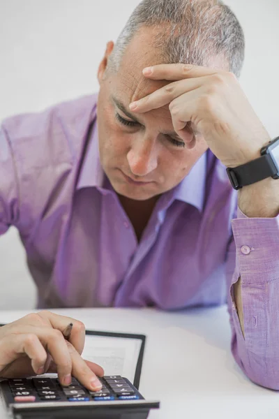 Uomo d'affari depresso con in mano una calcolatrice — Foto Stock