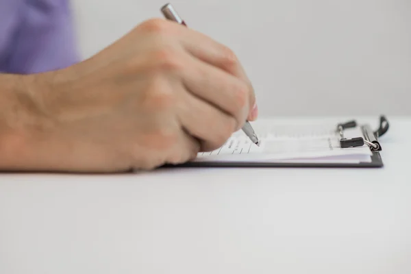 Jonge man met een potlood, op een papier in het dagboek schrijft — Stockfoto