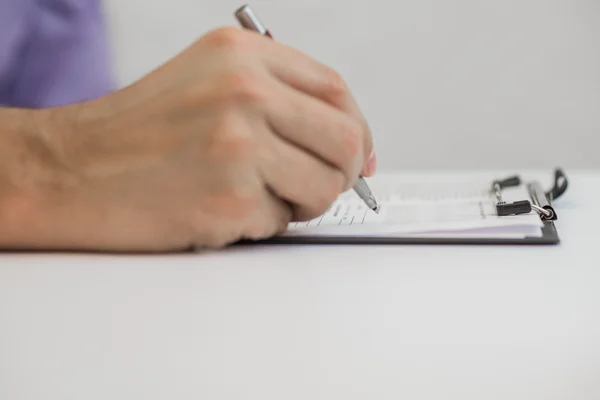 Jovem segurando um lápis, escrevendo em um papel no diário — Fotografia de Stock