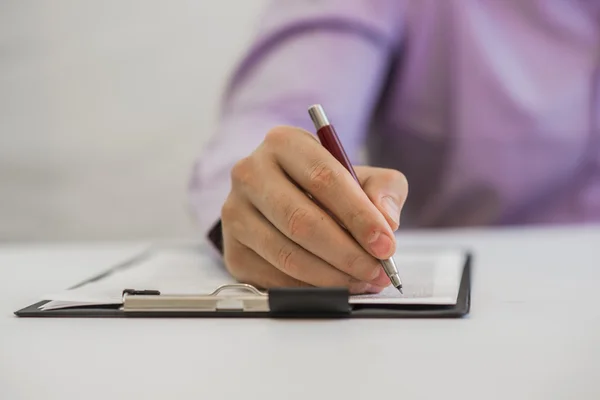 Empresário fazendo anotações sobre o papel em seu escritório — Fotografia de Stock