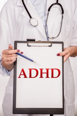 Doktor eller gösterir sözcüğü DEHB (dikkat eksikliği hiperaktivite bozukluğu). Tıbbi kavramı. Bir doktor bir Pano beyaz arka plan üzerinde tutarak stetoskop ile detay