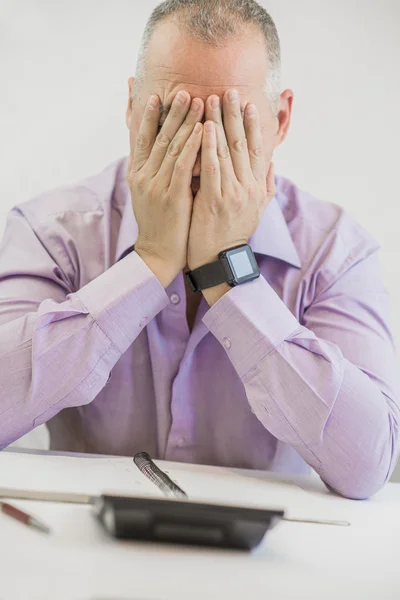 Mi sento esausta. Frustrato giovane uomo tenere gli occhi chiusi mentre seduto al suo posto di lavoro in ufficio — Foto Stock
