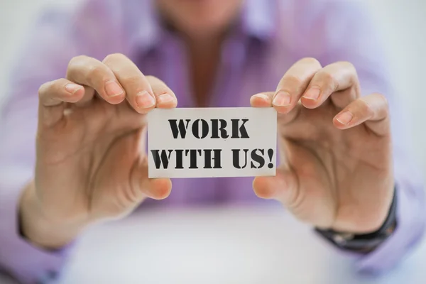 WORK WITH US! message on the card shown by a businessman