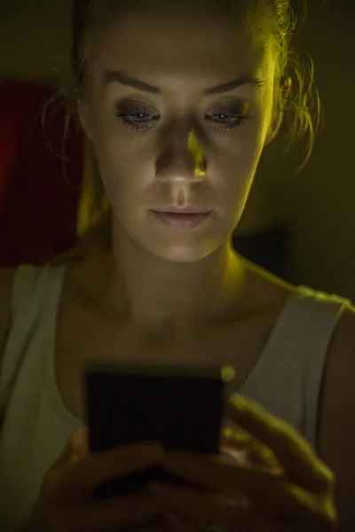 Boldogtalan tizenéves lány küldött szöveges üzenet éjjel otthonában — Stock Fotó
