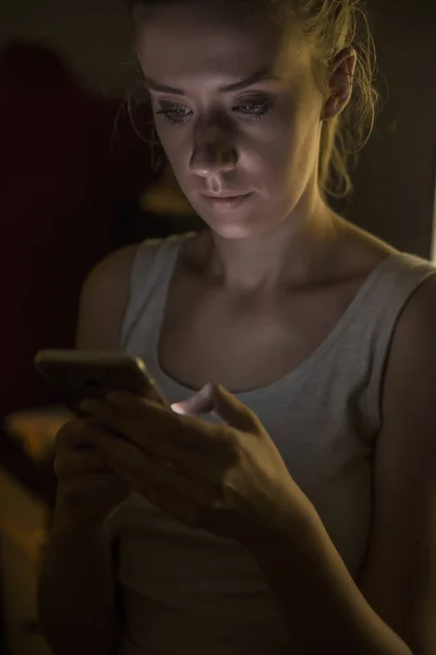 Technology, internet, communication and people concept -  young woman texting on smartphone at home  at night — Φωτογραφία Αρχείου