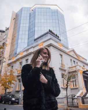 Sokakta duran ve cep telefonu kullanarak güzel genç kadın