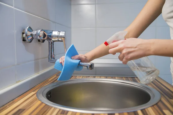 Joven ama de casa eliminación de manchas y pulido encimeras de cocina — Foto de Stock