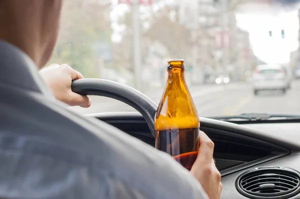 Homme main tenant bouteille de bière tout en conduisant la voiture — Photo