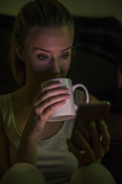 Cep telefonu kullanan kadın. Kadın holding Kupası ve kahve.