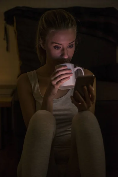 在咖啡馆喝咖啡，使用移动电话的年轻女子 — 图库照片