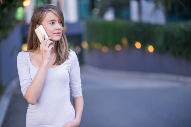 Bir telefon görüşmesi için bir smartphone kullanarak sohbet genç iş kadını