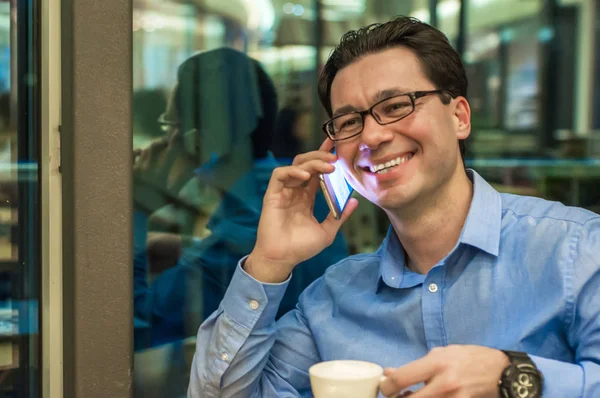 Immagine autentica di un uomo d'affari che lavora in un bar. Un uomo che parla al cellulare in una caffetteria — Foto Stock