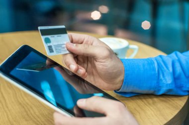 On-line satın almak için kredi kartı ve dijital tablet kullanarak iş adamı. Adam Internet üzerinde satın alma