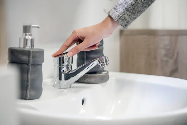 Primer plano de una mujer lavándose las manos con espuma de jabón sobre el lavabo del baño — Foto de Stock