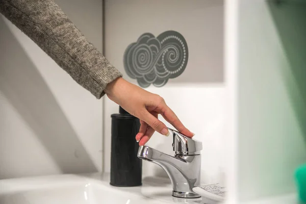 Primer plano de una mujer lavándose las manos con espuma de jabón sobre el lavabo del baño — Foto de Stock