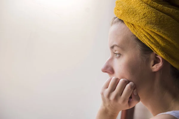 Perfil retrato de uma jovem mulher sentada sozinha olhando para a janela.Menina triste perto da janela pensando em algo . — Fotografia de Stock