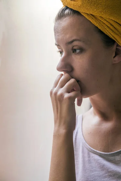 Vacker flicka står vid den fönstret titta på. vackra ledsen ensam flicka sitter nära fönstret saknas — Stockfoto