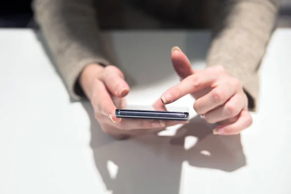 Vista de perto da mulher de negócios usando seu telefone em sua mesa no escritório. Mulher usando uma tela sensível ao toque de smartphone na mesa de madeira — Fotografia de Stock