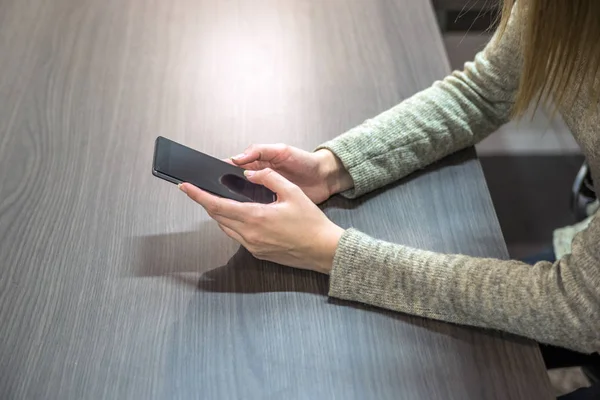 Empresária trabalhar em ambiente de escritório. Visão de perto de empresária usando seu telefone em sua mesa no escritório — Fotografia de Stock