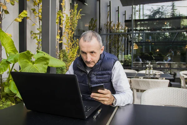 Homem de negócios usando internet no telefone inteligente e laptop. Empresário usando laptop e telefone celular — Fotografia de Stock