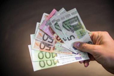 Siyah arka plan üzerinde bir sürü para, el tutan el a yelpaze-in farklı miktarda Euro tutan el izole euro ile adam elini euro para