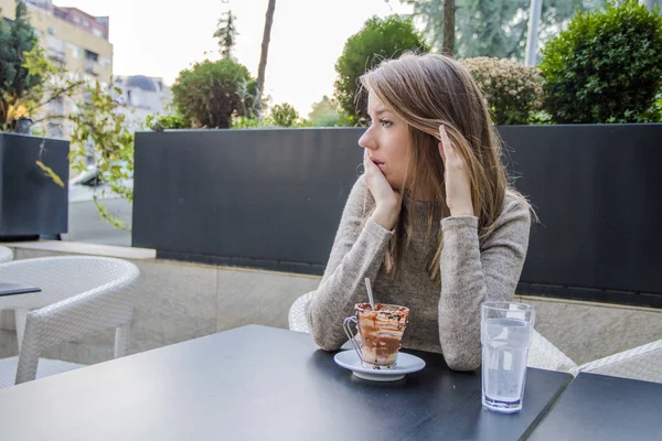 young woman waiting someone who late, and looking for her boyfriend in coffee shop. Portrait of young unhappy stressed beautiful female sitting in modern urban cafe. Woman so sad at coffee shop. Young Girl waiting someone who late