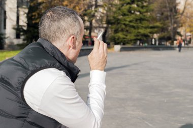 Madde bağımlılığı, bağımlılık, insanlar ve kötü alışkanlıkları kavramı - genç adam Sigara İçilmeyen açık havada kapatın. Adam sokakta sigara duman