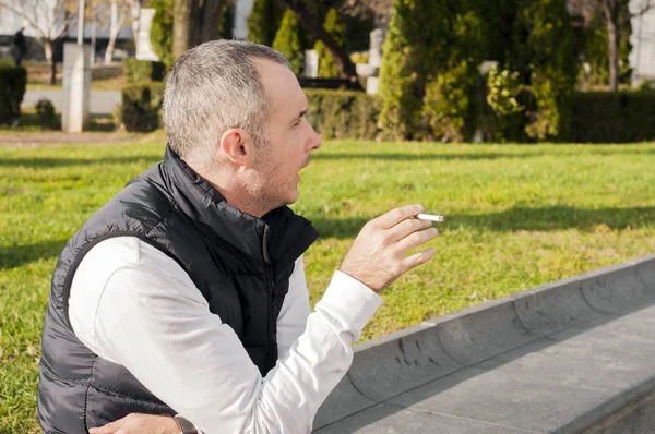 Knappe stijlvolle jongeman roken buiten in stedelijke omgeving, op zoek weg. knappe witte man een buiten op een zonnige dag sigaretten roken — Stockfoto