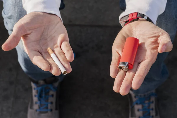 Mano sosteniendo encendedor y cigarrillo, abuso de sustancias, adicción y malos hábitos concepto - primer plano de los jóvenes fumando cigarrillos al aire libre —  Fotos de Stock