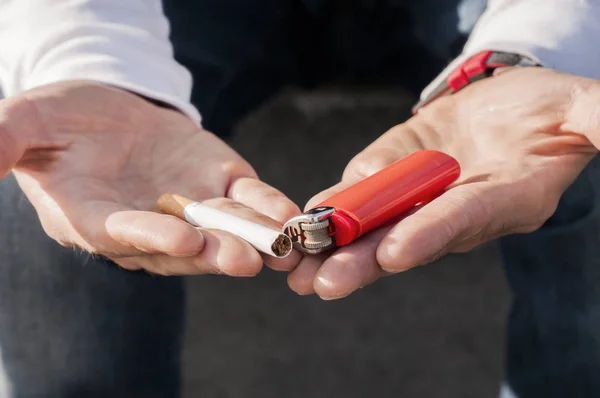 Mano sosteniendo encendedor y cigarrillo, abuso de sustancias, adicción y malos hábitos concepto - primer plano de los jóvenes fumando cigarrillos al aire libre —  Fotos de Stock