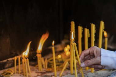 Adam el ışık mumlar bir kilise, mumlar ve yeni bir muma koyarak el.