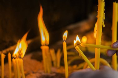 Adam el ışık mumlar bir kilise, mumlar ve yeni bir muma koyarak el.