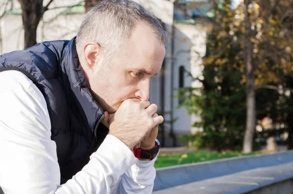 Profil latéral stressé jeune homme d'affaires assis à l'extérieur du bureau d'entreprise tenant la tête avec les mains regardant vers le bas. Émotion humaine négative sentiments d'expression faciale. Un homme stressé. portrait émotionnel — Photo