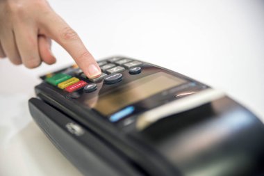 Terminal close-up. Müşteri parmak pos makinede düğmesine basın. POS eller terminal.