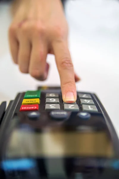 Kreditkort reader maskin på vit bakgrund. Kort maskin eller pos terminal med infogade tomma vita kreditkort isolerad på vit bakgrund. Handen och fingrarna PIN-kod med en hand höll PIN-pad. Stockbild