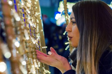 Genç gülümseyen kız öpücük üfleme Noel için dört gözle. Mutlu kadın üzerinde avuç içi öpücük sokak Noel backg karşı esen