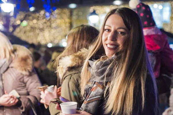 밤에 축제 크리스마스 시장에 여자입니다. 밤에 도시 크리스마스 분위기를 느끼고 행복 한 여자 — 스톡 사진