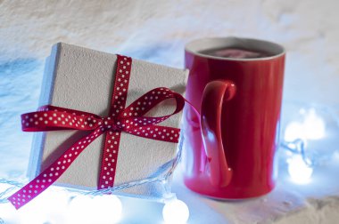 Kırmızı sıcak kakao fincan. Noel tarzı. karlı zemin üzerine sıcak içecek bir fincan. Sıcak çikolata Kupası ve Noel hediye kutuları. Kopya alanı ile göster