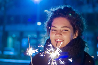 Maytap tutan kadın elinde kapatın. Maytap gece mutlu kadınla