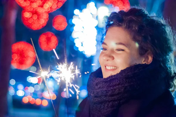 Mujer joven sosteniendo una bengala encendida para celebrar el año nuevo. mujer divirtiéndose con un chispeante — Foto de Stock