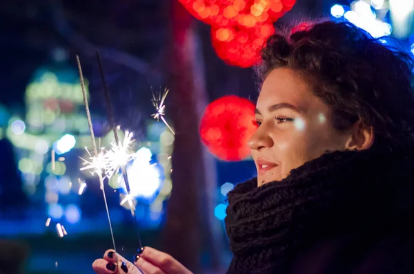 女性は、線香花火を楽しんでします。若い女性がクリスマスを祝います。クリスマス女性持株花火 — ストック写真