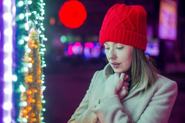 Noel ağacı düşünürken tarafından üzgün bir kadın. Kış geceleri sokak yalnız Noel kadınlarda. Üzgün ararken Noel şenlikli esmer