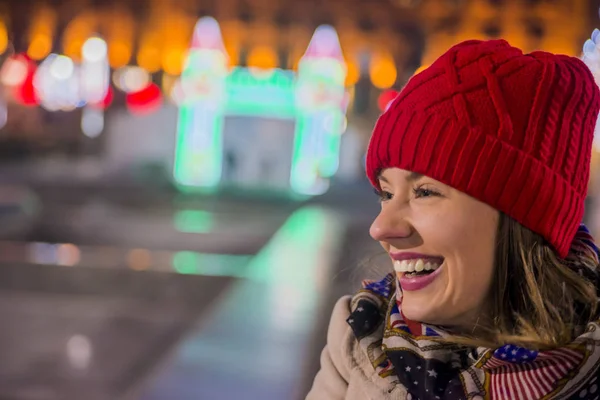 夜の都市のクリスマスの雰囲気を感じて幸せな女。クリスマスの光を見上げて夜幸せな女 — ストック写真