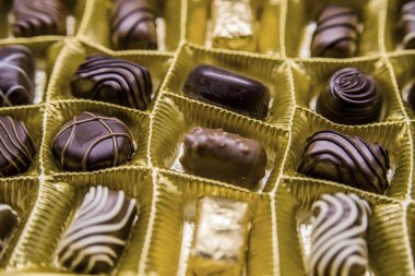 Çeşitli lezzetli çikolatalı pralin arka plan. Bir kutu içinde koyu çikolata şekerleme. Çeşitli çikolatalı pralin