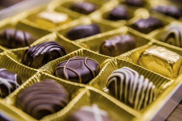 Box of chocolates at an angled overhead view with a shallow depth of field. A selection of chocolates.
