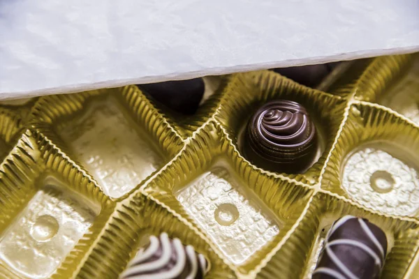 A box of chocolates partially empty viewed from above. Luxurious Chocolates in various shapes and flavors in a gift bo