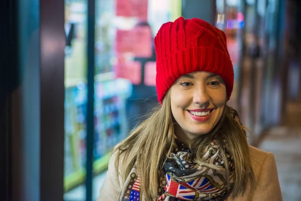 Естественный портрет привлекательной улыбающейся женщины в красной вязаной шапке из шерстяной шапки крупным планом. Красота покупает рождественские скидки — стоковое фото